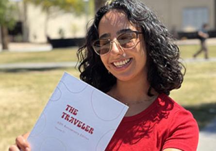 GCC Student holding the 60th Anniversary edition of "The Traveler"